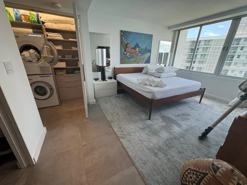 A clean, bright bedroom with a made bed and polished floor
